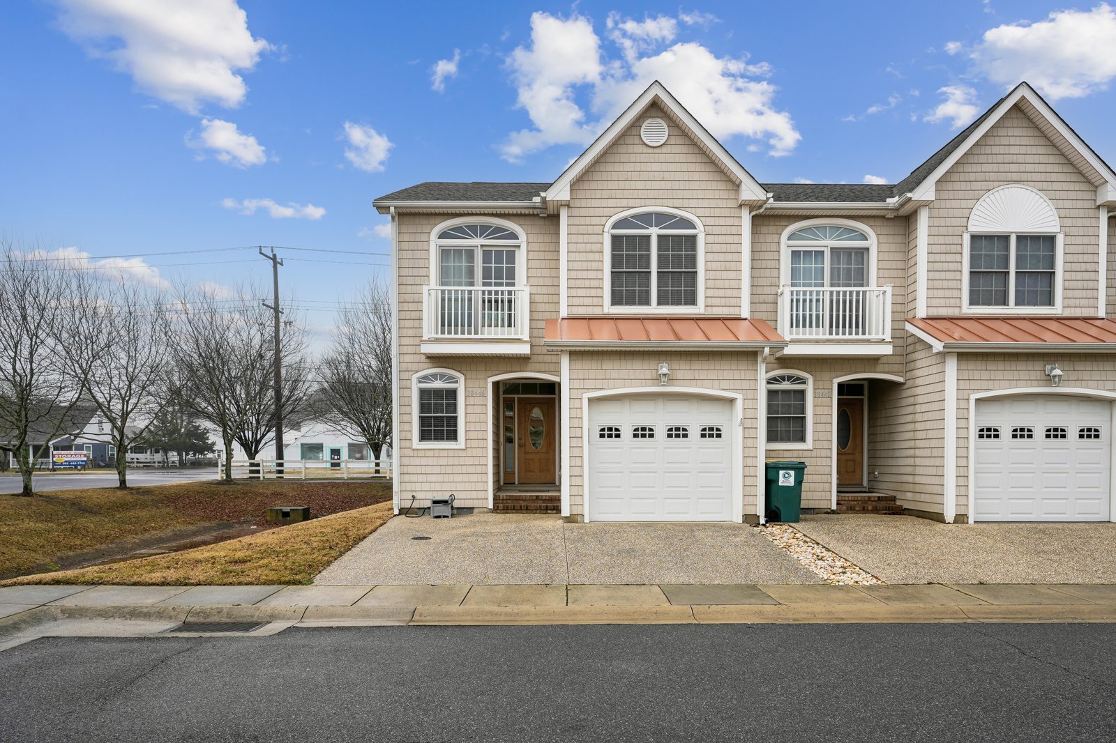 Modern townhome exterior with classic architectural details and convenient attached garage parking in a quiet residential neighborhood.