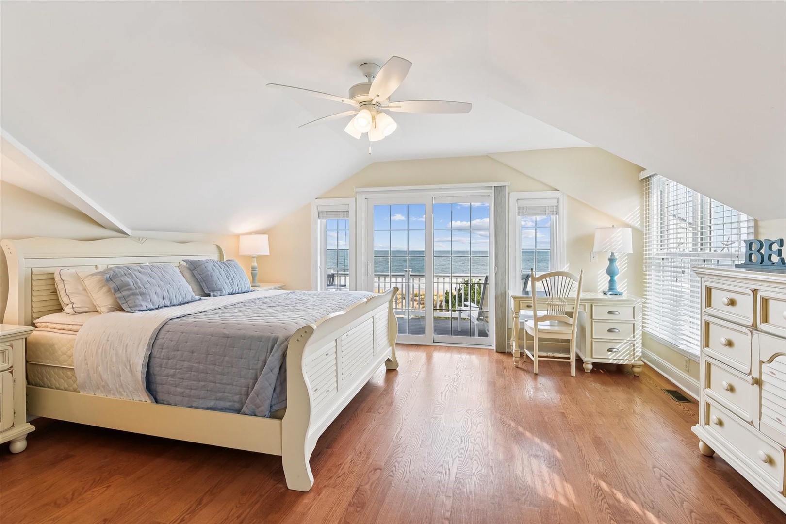 Wake to stunning water views from your coastal retreat with a king bed, warm wood floors, and glass doors opening to a private balcony where gentle breezes greet each morning.