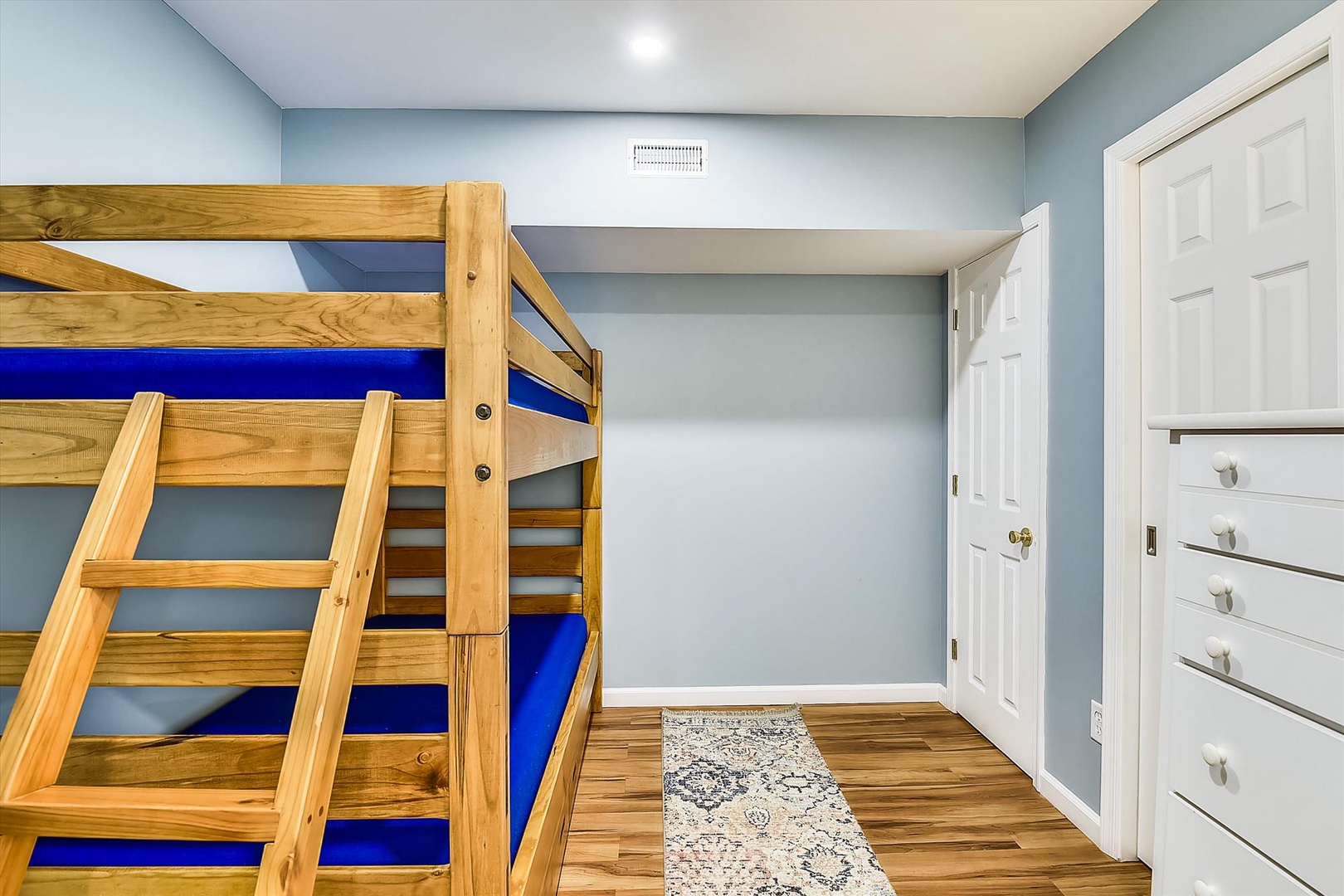 Gather the crew in this fun bunk room with sturdy wood bunks and soft blue mattresses. Perfect for kids or friends sharing adventures together!