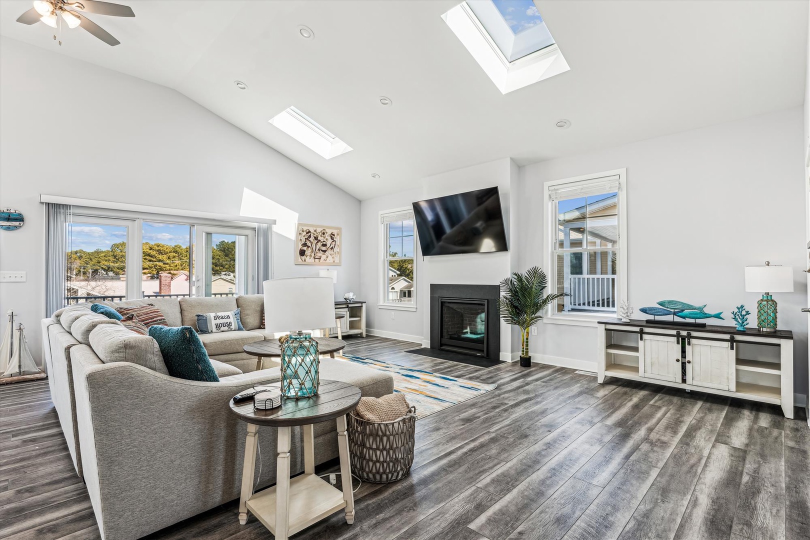 Sink into plush sofas beneath soaring skylights that flood your airy living room with natural light. Cozy up by the fireplace or enjoy entertainment on the large TV in this beautifully designed coastal retreat.