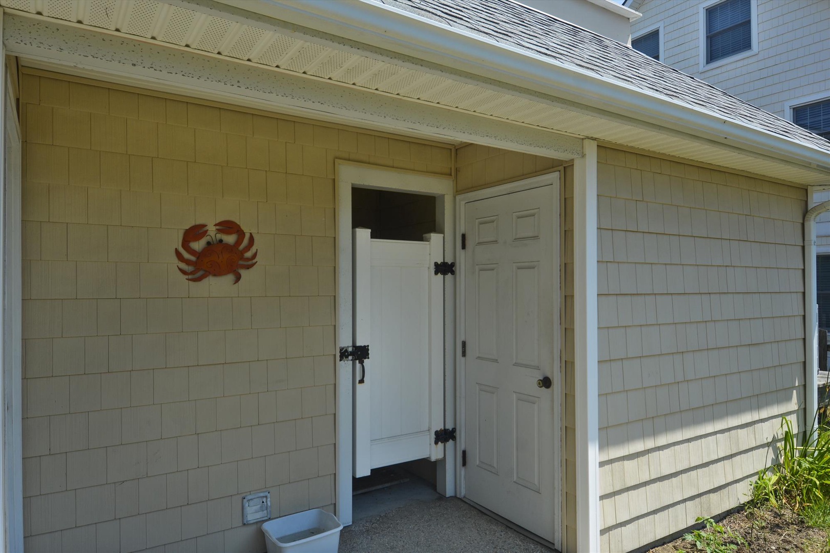 Exterior entryway marked by a decorative crab accent, offering a welcoming coastal charm at the property's secondary access.