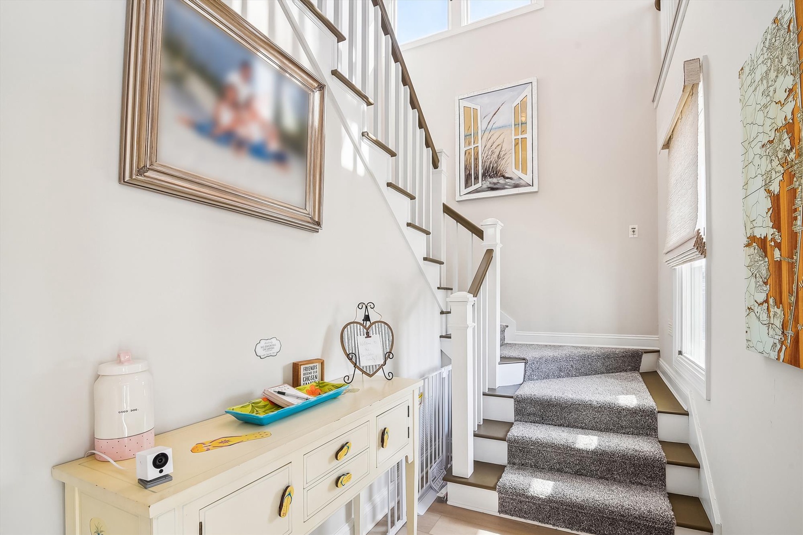 Step into your bright, airy retreat where coastal artwork and soaring ceilings welcome you home. Sunlight streams through tall windows, illuminating thoughtful details and setting a peaceful, beachy tone for your stay.