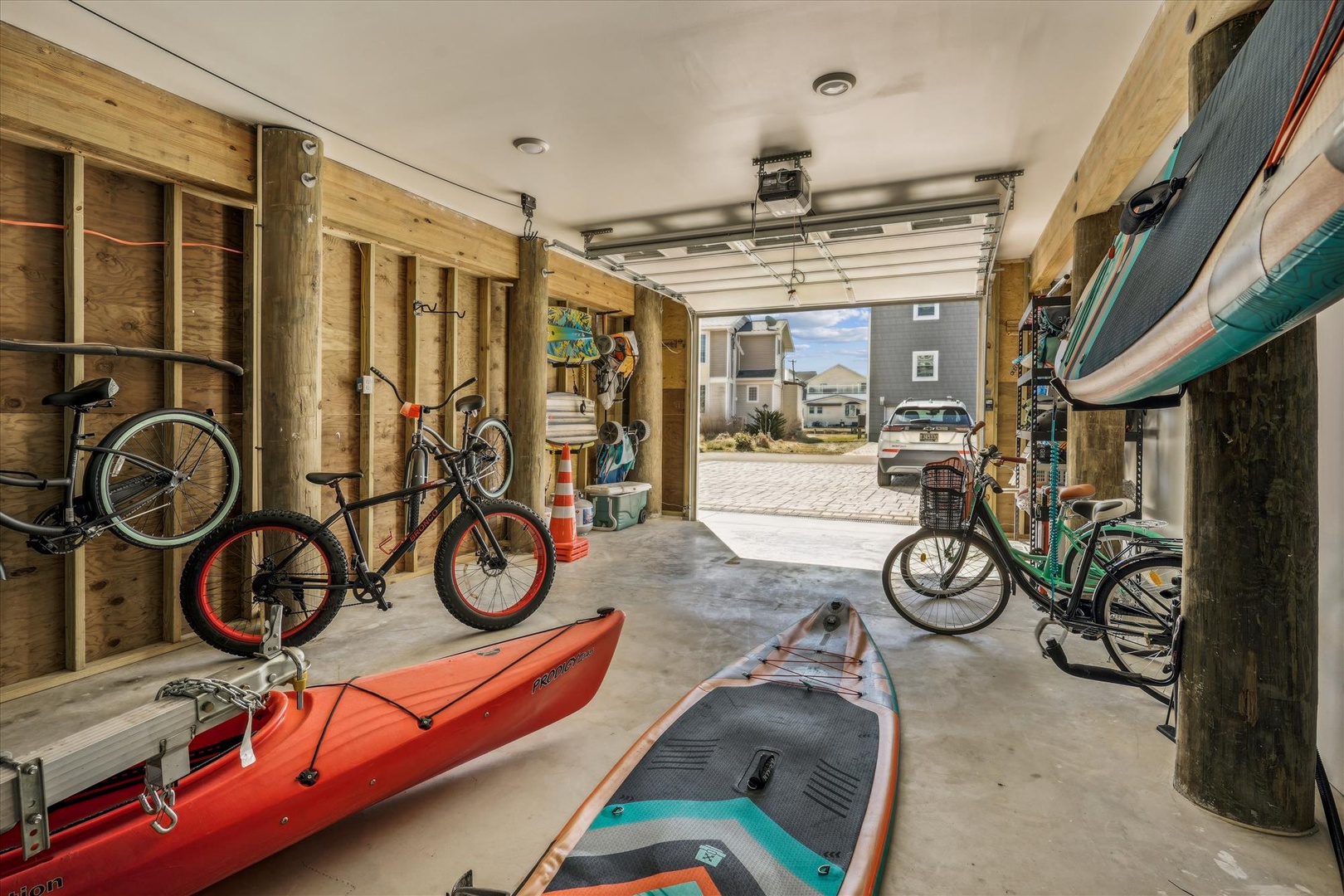 Your adventure gear awaits in this organized garage with bikes, kayaks, and paddleboards ready for coastal exploration.