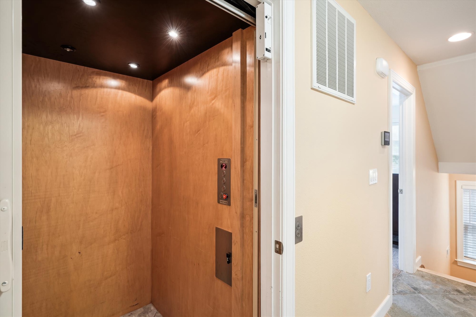 Easily accessible elevator with warm wood paneling ensures effortless movement throughout your stay.
