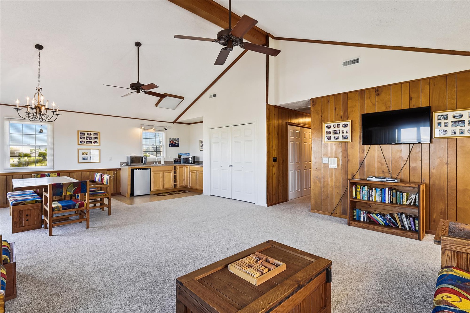 Spacious gathering area with soaring ceilings, warm wood details, and entertainment options—perfect for family game nights or relaxing with your favorite book and movie.