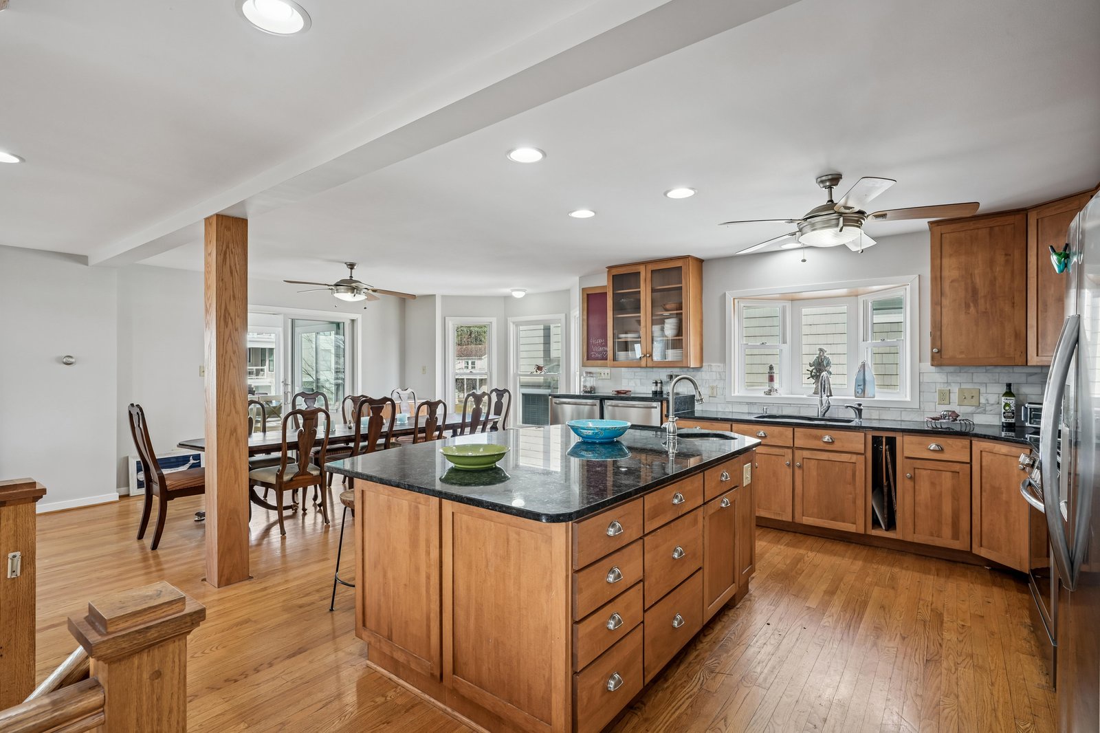 Your spacious kitchen invites you to prepare meals together with granite countertops, warm wood cabinetry, a generous center island, and an adjacent dining table perfect for family gatherings.