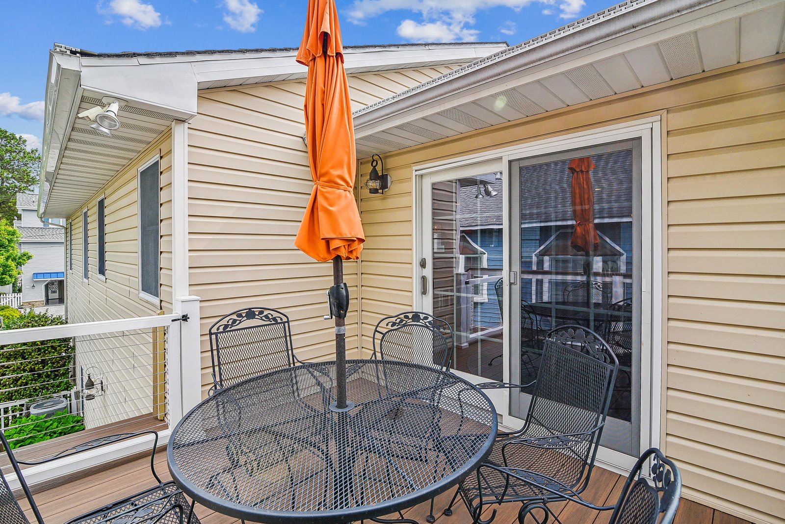 Your private outdoor deck with table for four and vibrant umbrella—perfect for morning coffee or evening meals under the open sky.