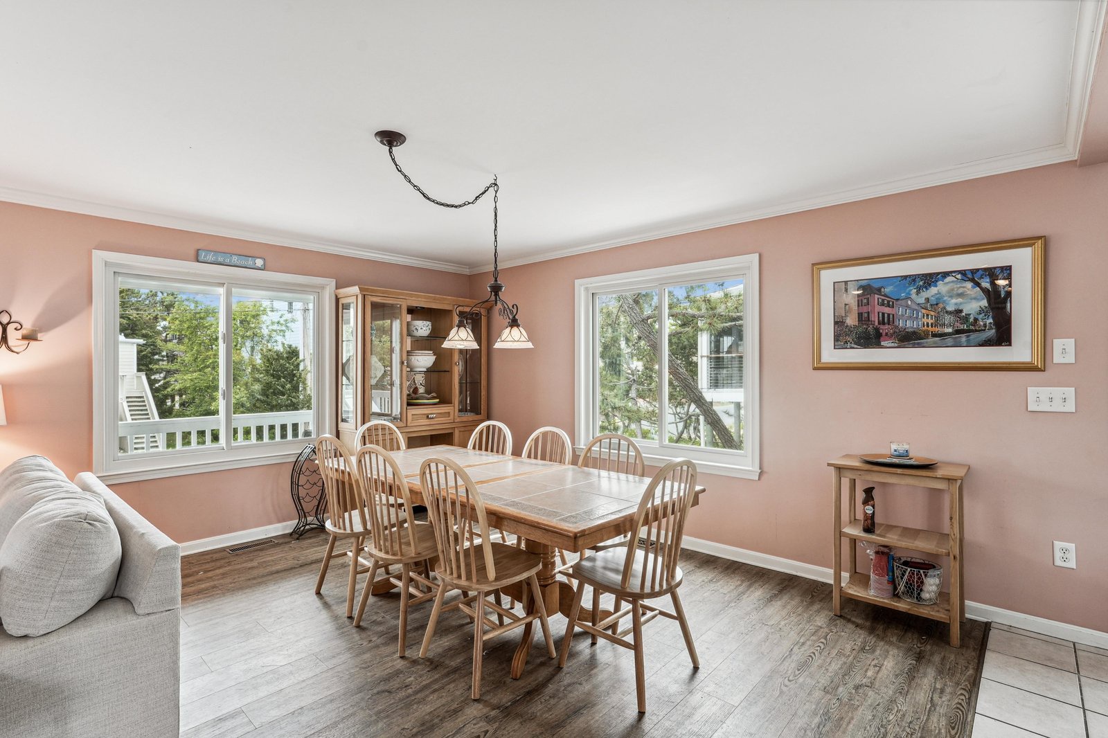 Your dining space overlooks leafy trees through bright windows, with room for everyone to gather around the table for memorable meals together.