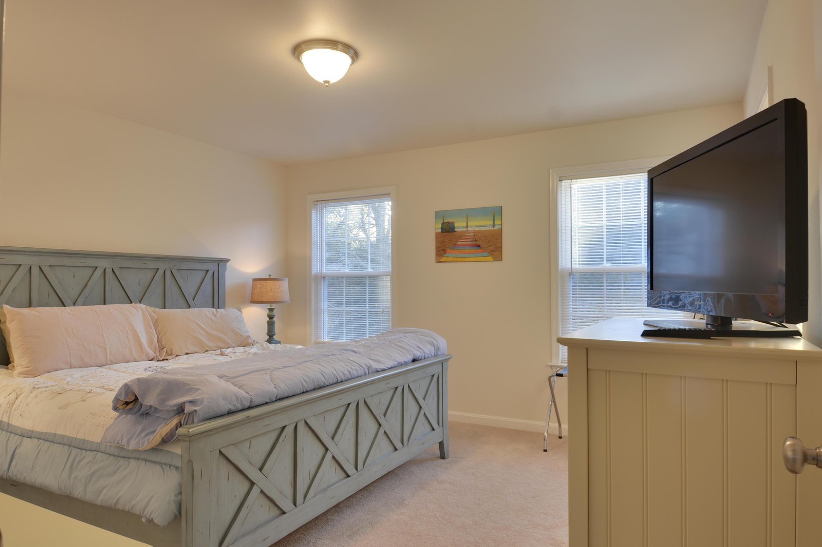 Step into your restful bedroom, where soft natural light pours through double windows and a plush bed awaits after your daily adventures.