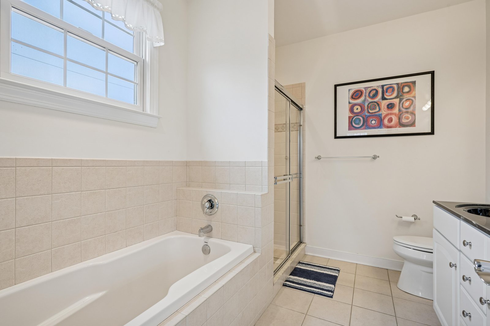 Bright, spacious bathroom with soaking tub, separate walk-in shower, and elegant tile work—your private retreat for unwinding after a day of adventure.
