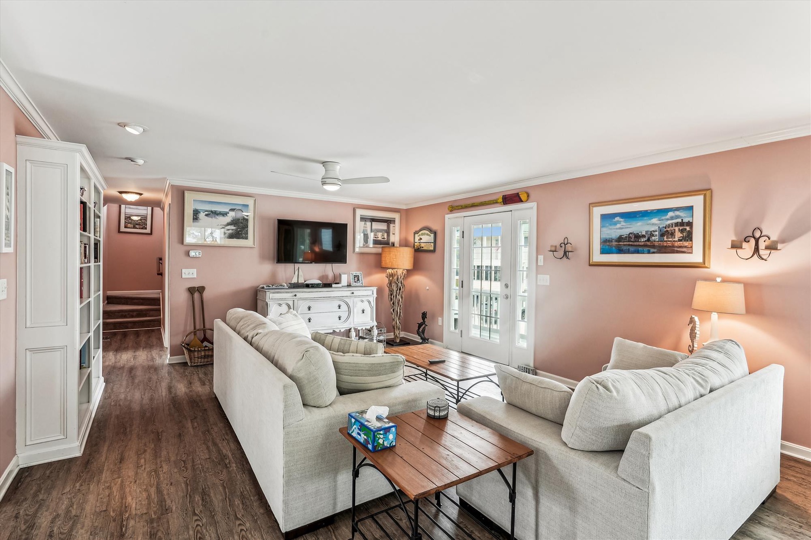 Relax in your cozy living space with soft coral walls, plush sofas, and warm wood floors that invite you to unwind after a day of adventure.