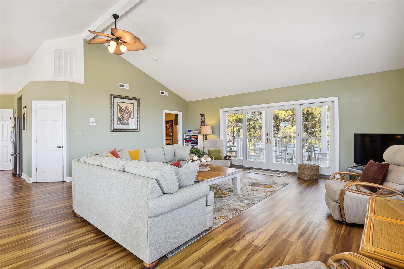 Unwind in your spacious living room where vaulted ceilings and French doors create an airy retreat perfect for relaxation.