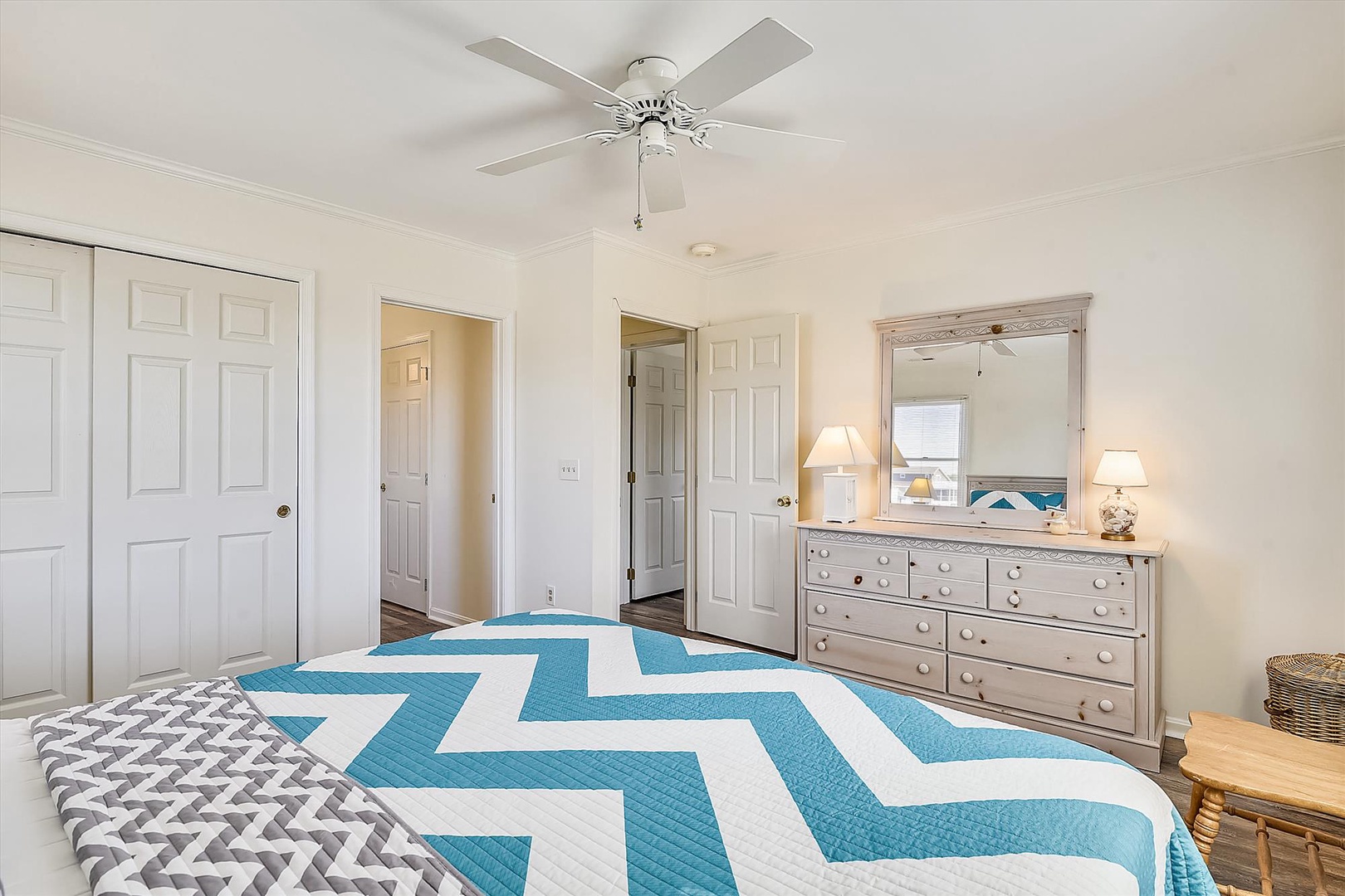 Drift off in your serene coastal retreat, where a bright chevron quilt and soft bedside lamps create the perfect sanctuary. Your charming dresser and closet offer plenty of storage space for a carefree stay.