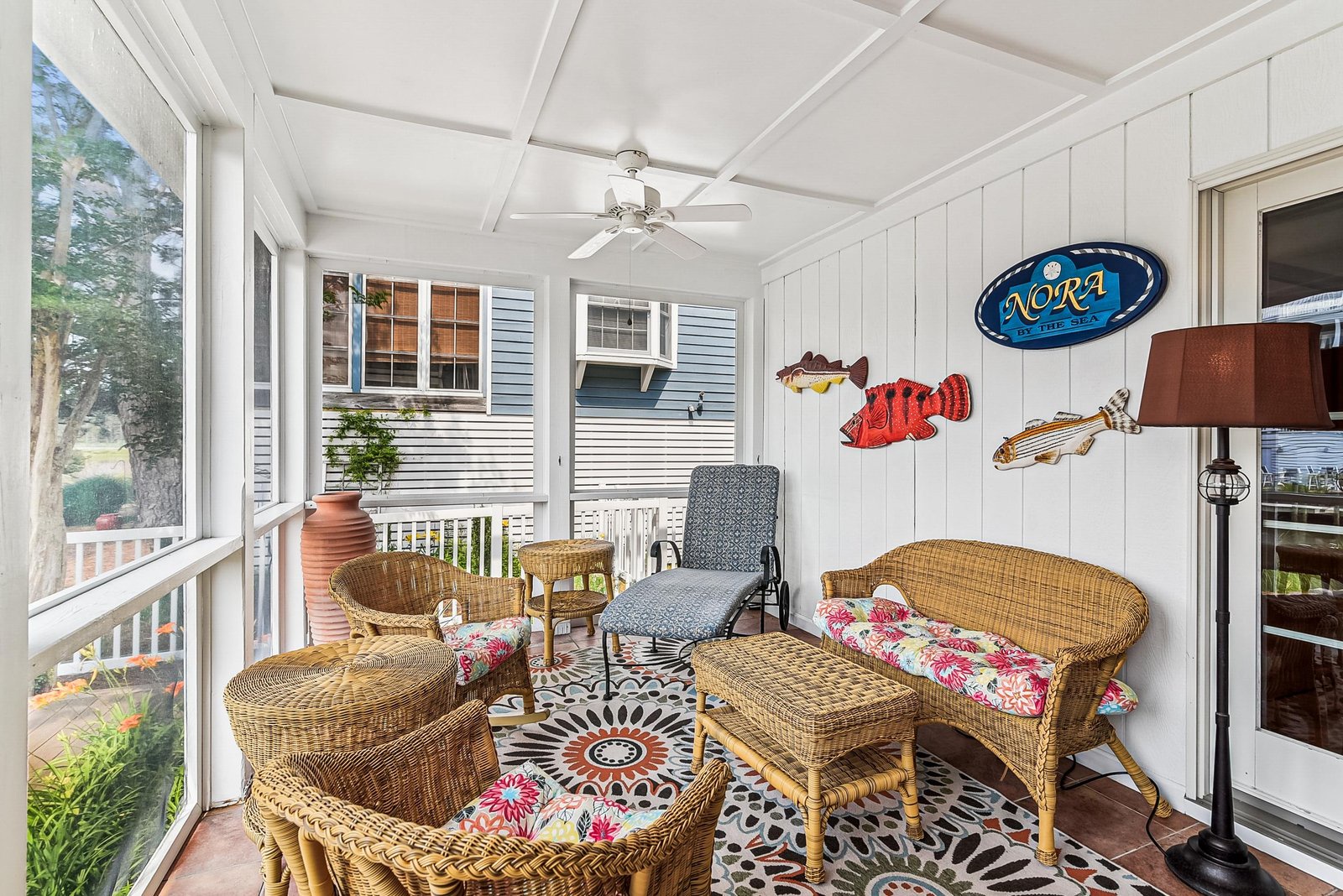 Settle into your bright sunroom sanctuary with cheerful wicker seating and playful coastal accents—perfect for morning coffee or afternoon relaxation overlooking the garden.