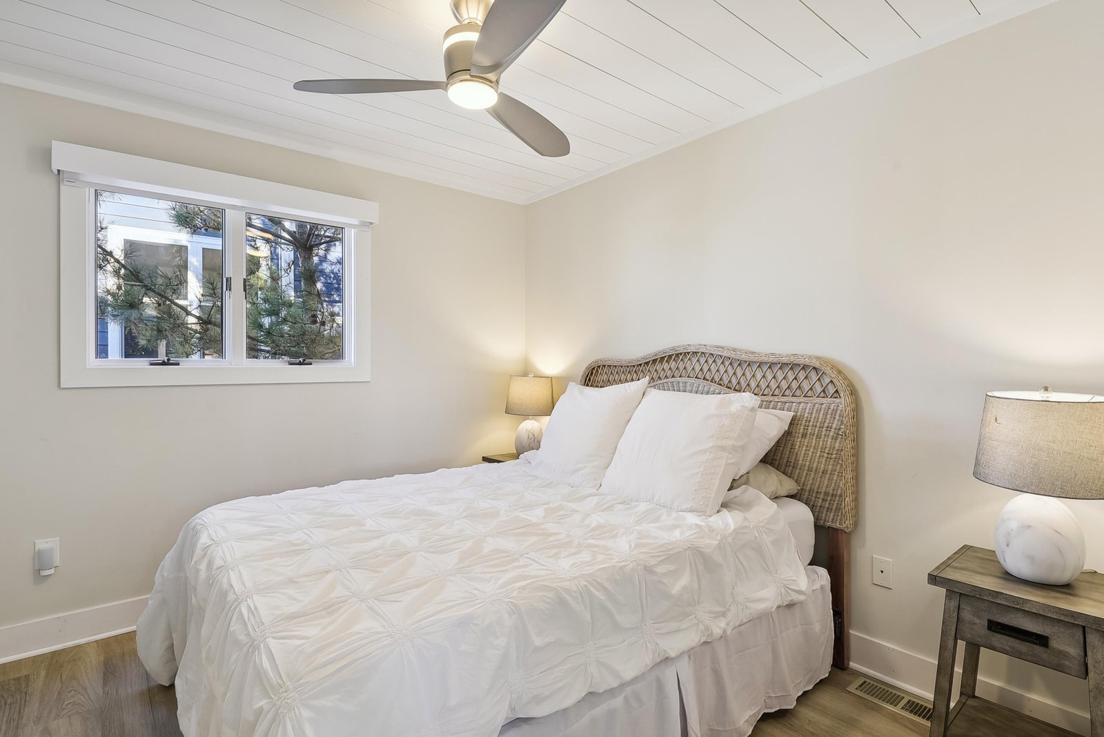 Slip into crisp linens and feel the coastal breeze from your ceiling fan. Natural light fills your serene retreat, while textured details and soft, neutral tones invite total relaxation.