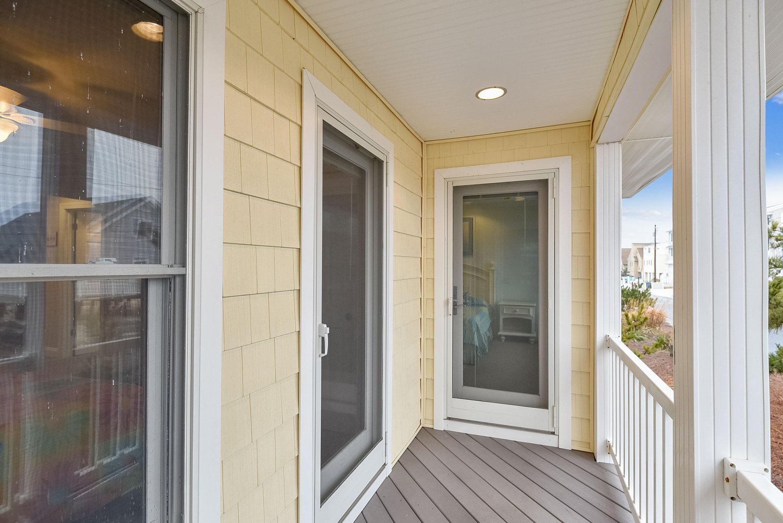 The property entrance is easy to identify with its clean white-framed glass door and welcoming covered porch area.