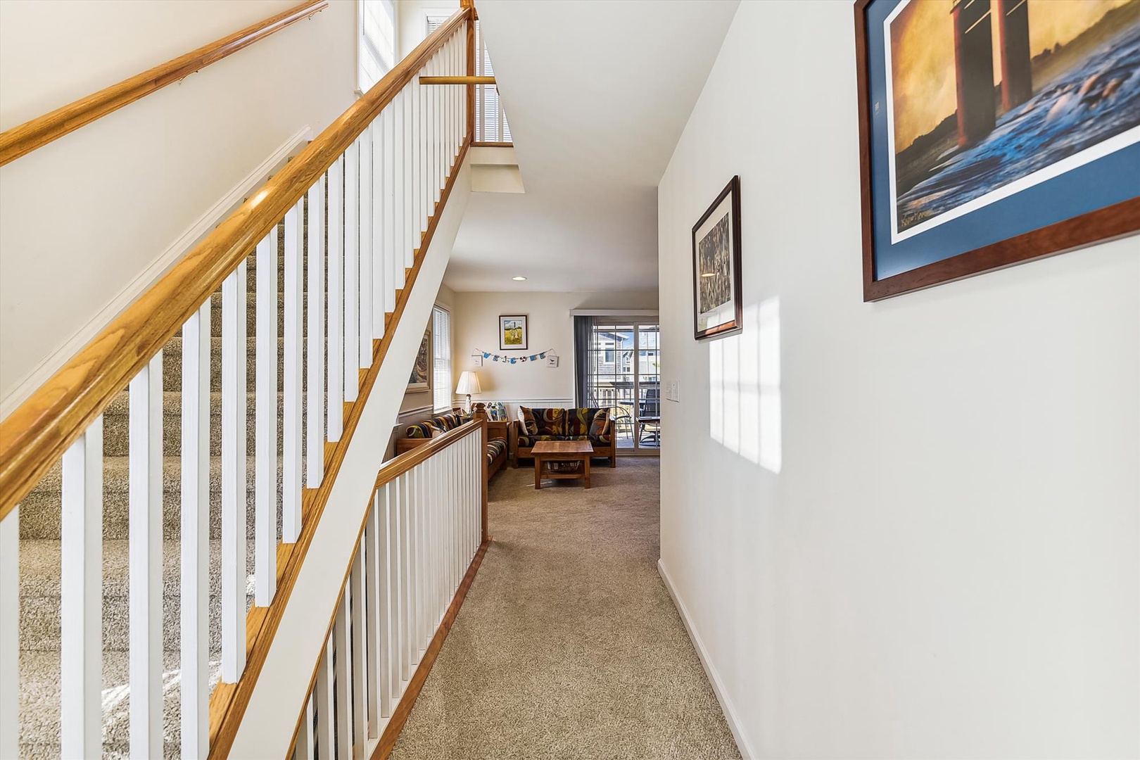 Natural light fills this spacious hallway, connecting your cozy living area to the upper level. The vaulted ceilings and warm wood accents create an inviting, open atmosphere perfect for unwinding.