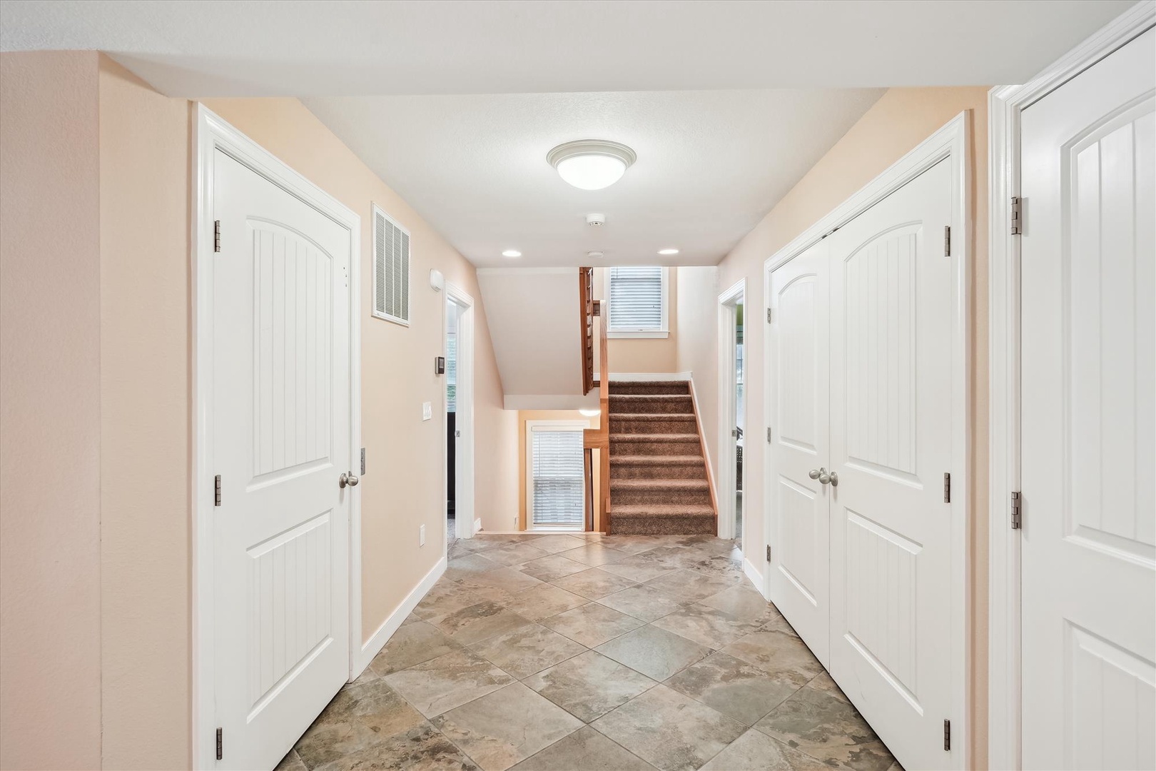 A welcoming entry hallway with warm tones and tile flooring leads you to your private retreat. Multiple rooms await your exploration, offering plenty of space to settle in and feel at home.
