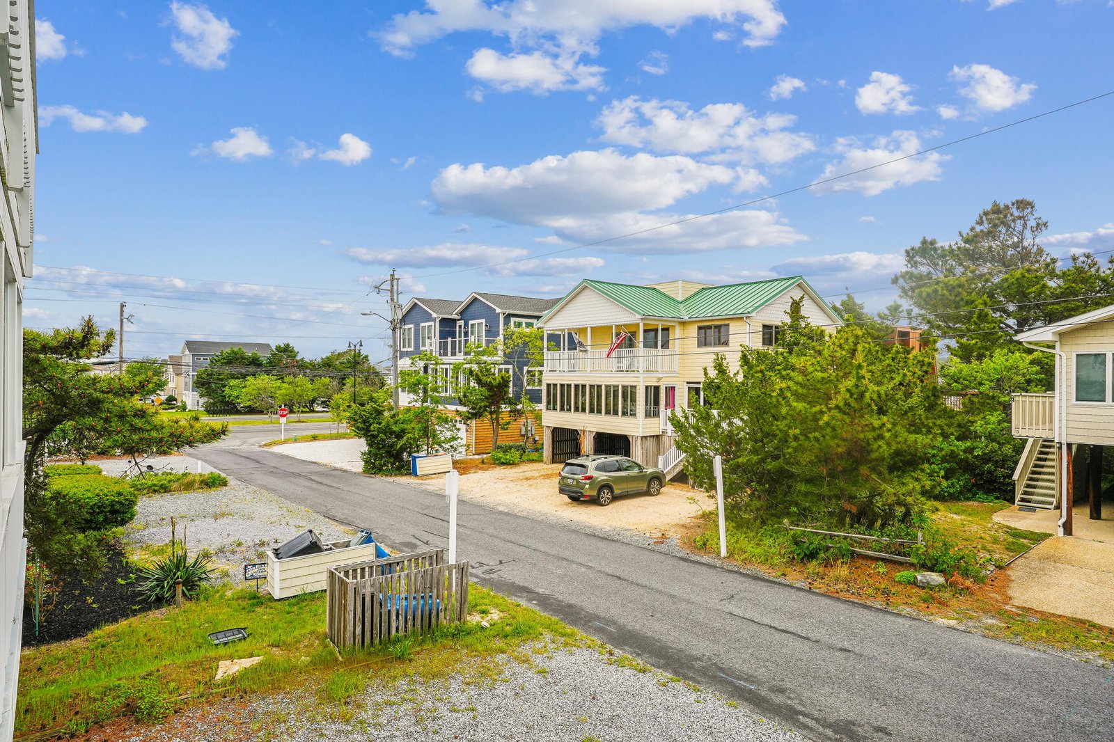 A peaceful residential street with nearby beach houses and easy access to the coast, welcoming guests to a relaxed, laid-back vacation atmosphere.