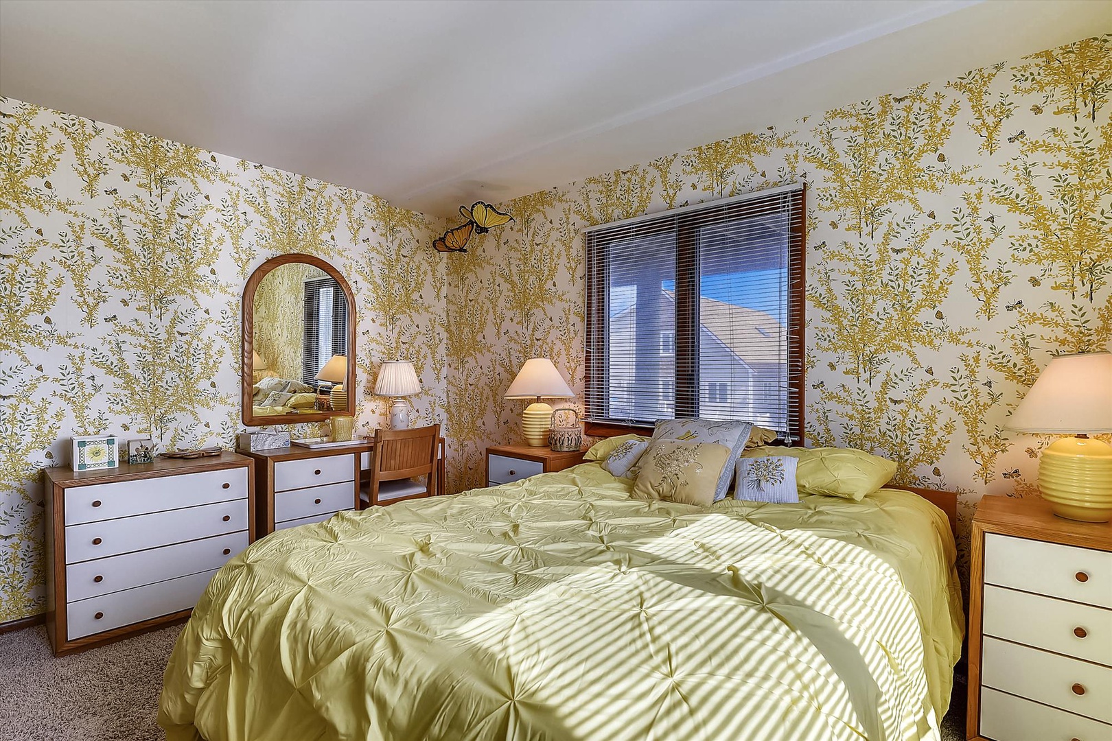 Slip into your serene bedroom retreat, where charming floral wallpaper and sunlit windows create a peaceful haven for restful nights and lazy mornings.