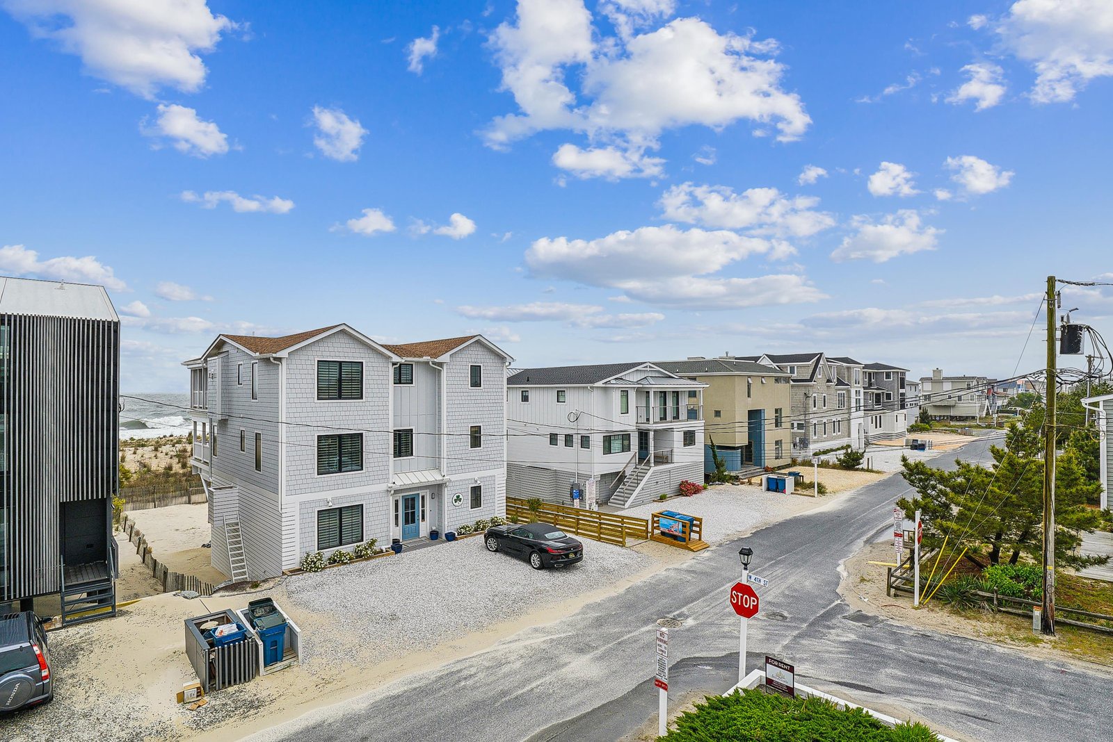 A coastal residential neighborhood with beachfront properties, sandy streets, and ocean access. The property sits among vacation homes in a quiet seaside community.