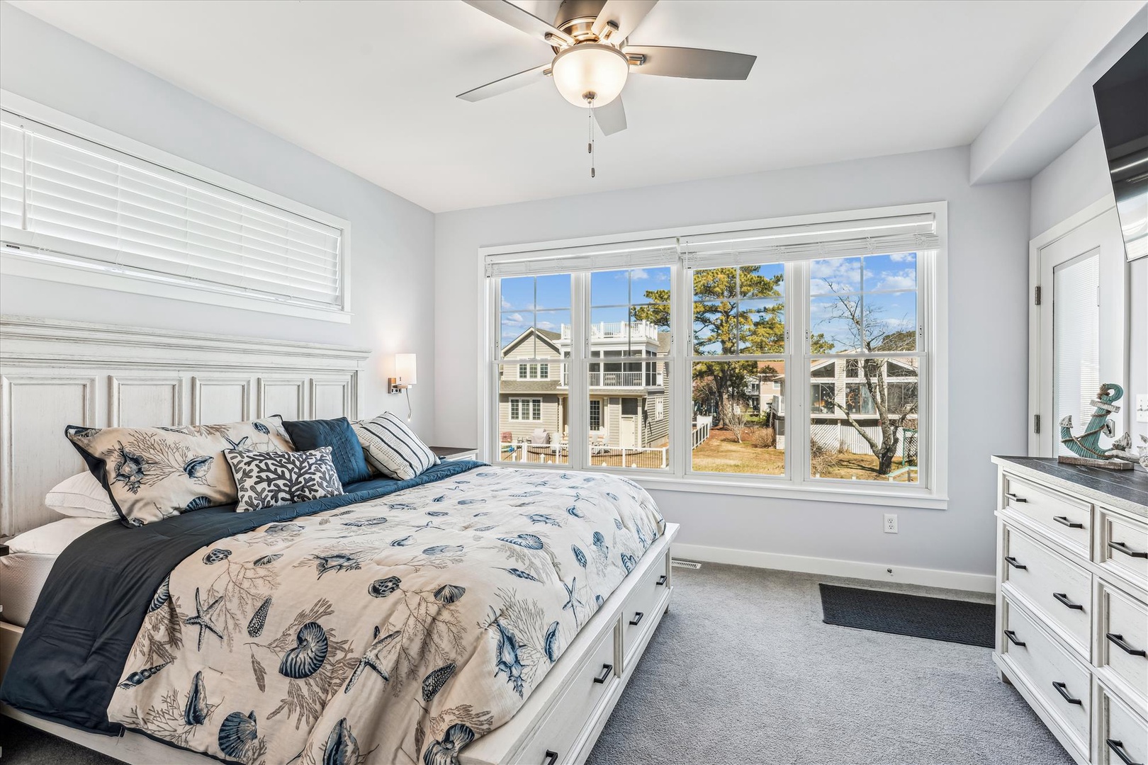 Sink into your coastal-inspired haven, where soft blue tones and natural light create a tranquil retreat, and a gentle ceiling fan keeps you comfortable year-round.