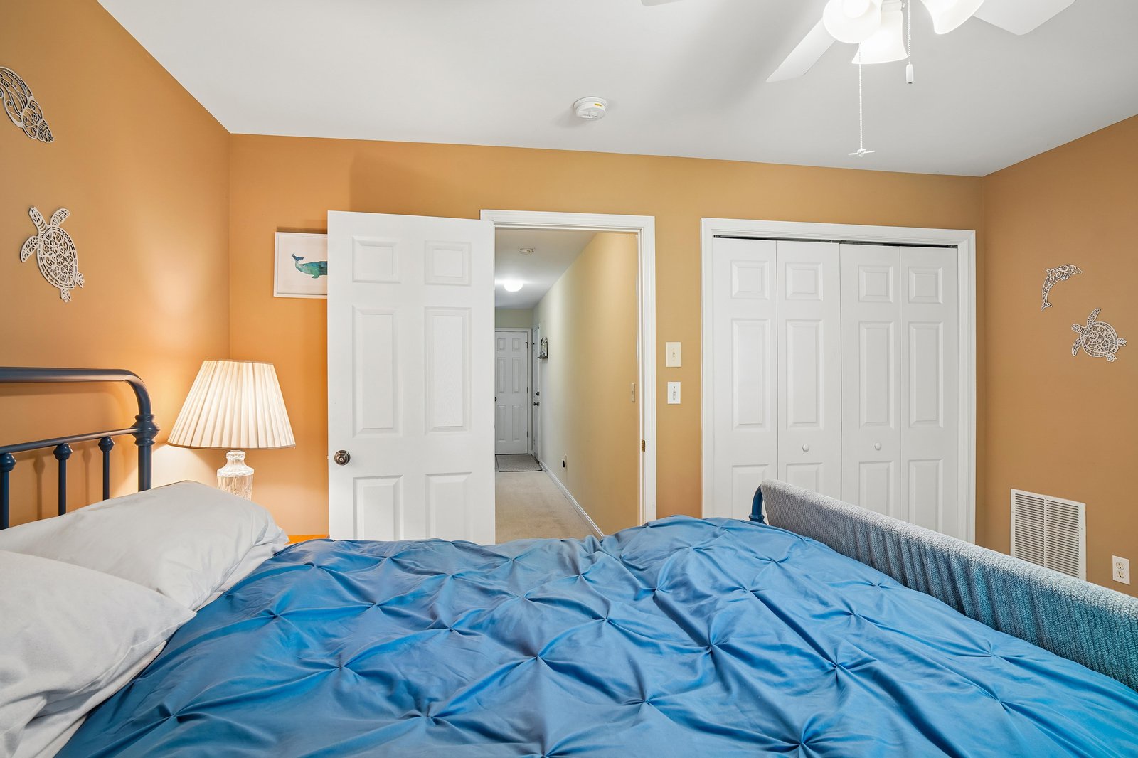 Drift off in this cozy bedroom with cheerful walls, soft lighting, and playful sea turtle accents that bring a coastal charm to your restful retreat.