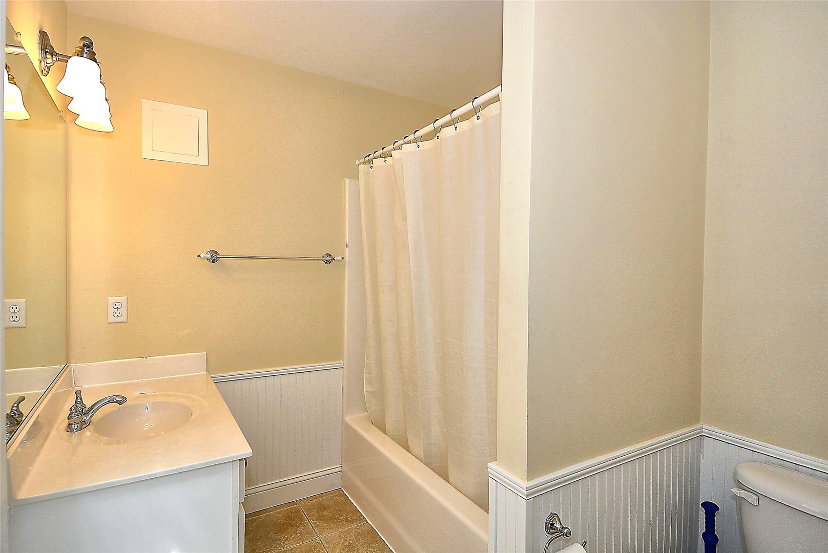 Step into a pristine bathroom where warm lighting and a full tub-shower combo invite you to refresh and unwind after your adventures.