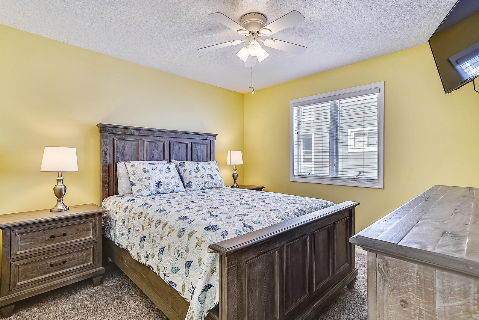 Settle into your cozy bedroom with rich wooden furnishings and cheerful yellow walls. The plush queen bed and soft lighting create the perfect retreat after a day of adventure.