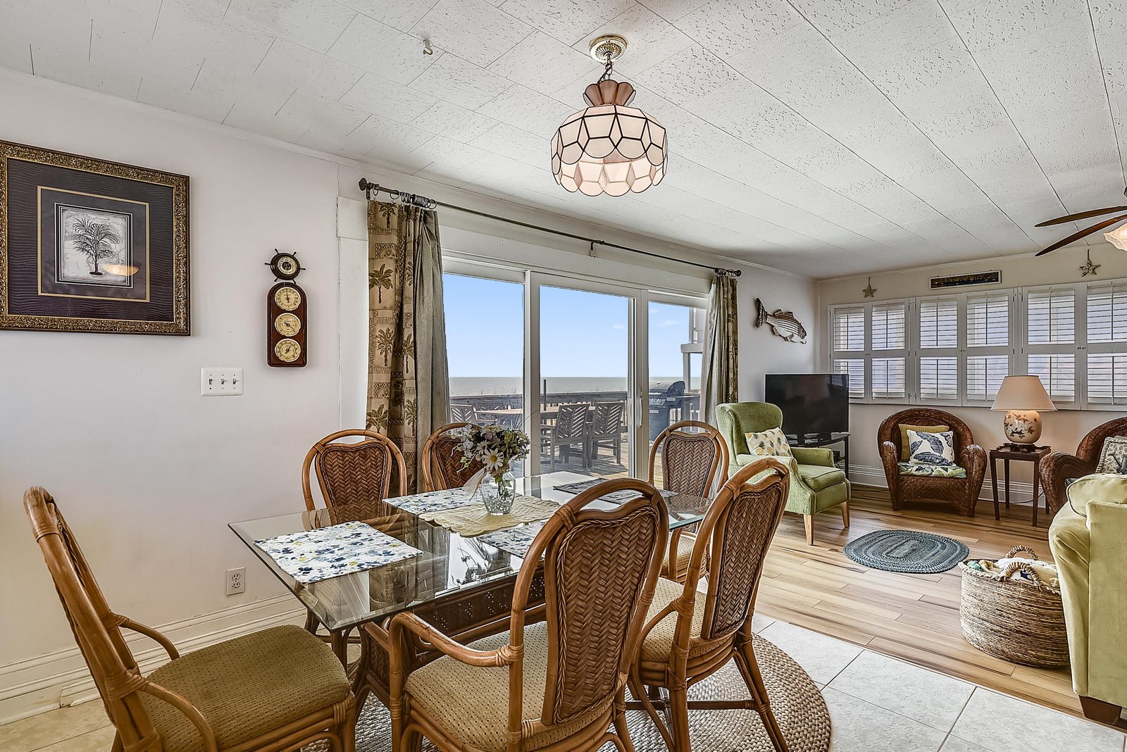 Relax in the bright living and dining area where coastal charm meets comfort. The open layout flows beautifully, with cozy seating and a dining table ready for your group meals, all bathed in warm natural light.
