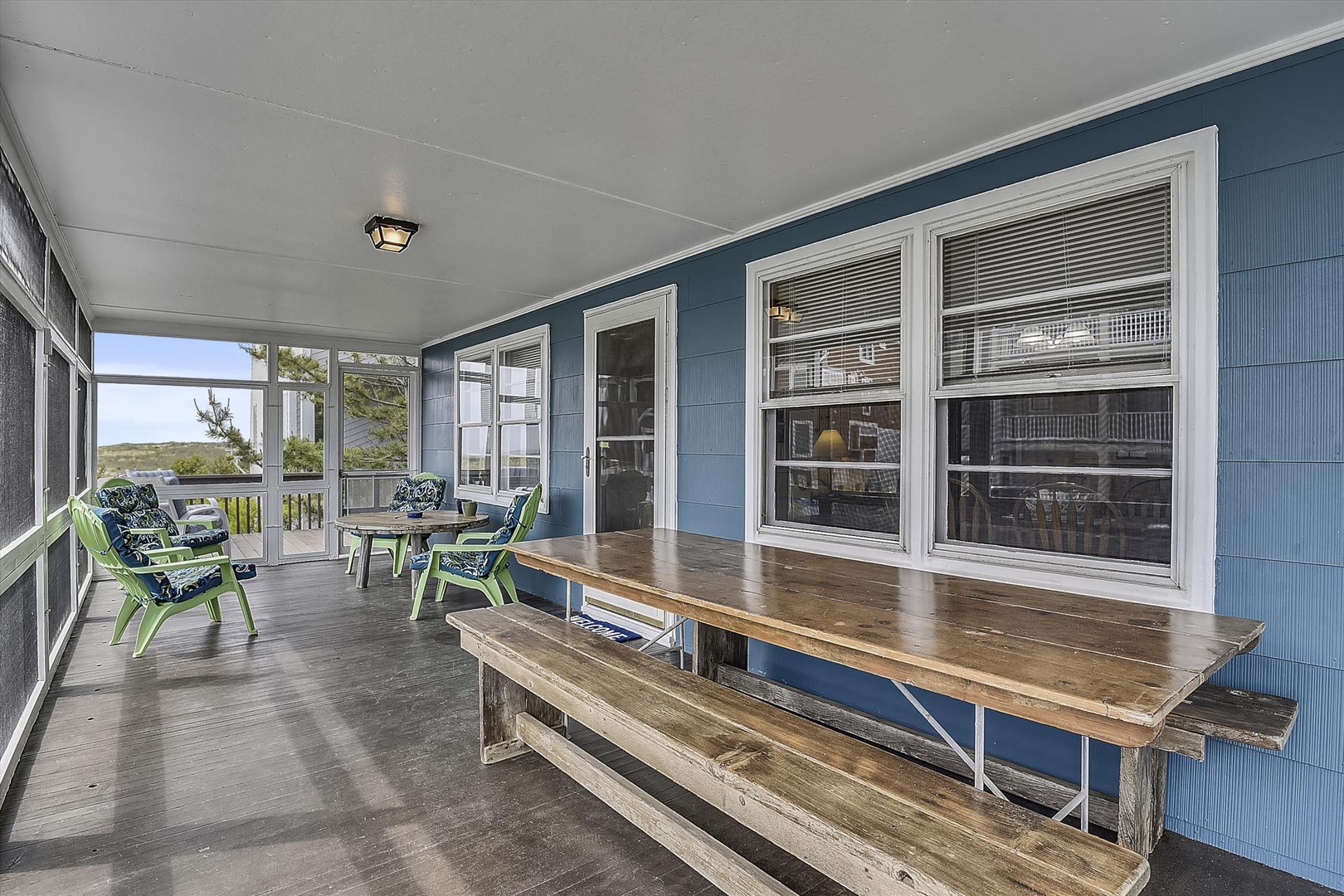 Gather with friends on your spacious screened porch, where fresh coastal breezes meet comfortable seating and peaceful views of the surrounding landscape.