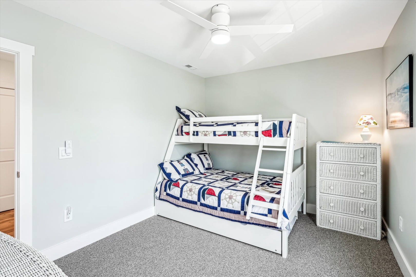 Perfect for families, this bright bedroom features a charming bunk bed with nautical-themed linens and plenty of storage space. Coastal touches create a relaxing retreat for your group.