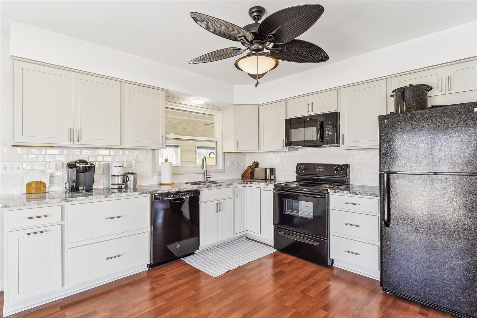 Your fully-equipped kitchen features white cabinetry, modern appliances, and warm wood floors—perfect for whipping up vacation meals together.