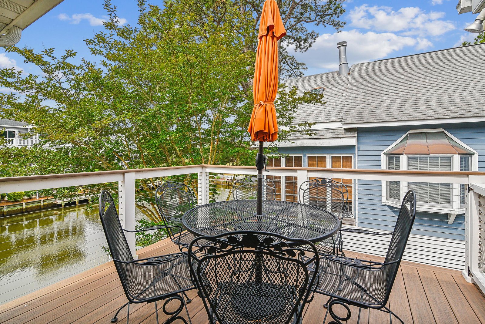 Picture yourself sipping morning coffee or evening wine at this peaceful waterfront table, where lush greenery and tranquil water views create your private oasis.