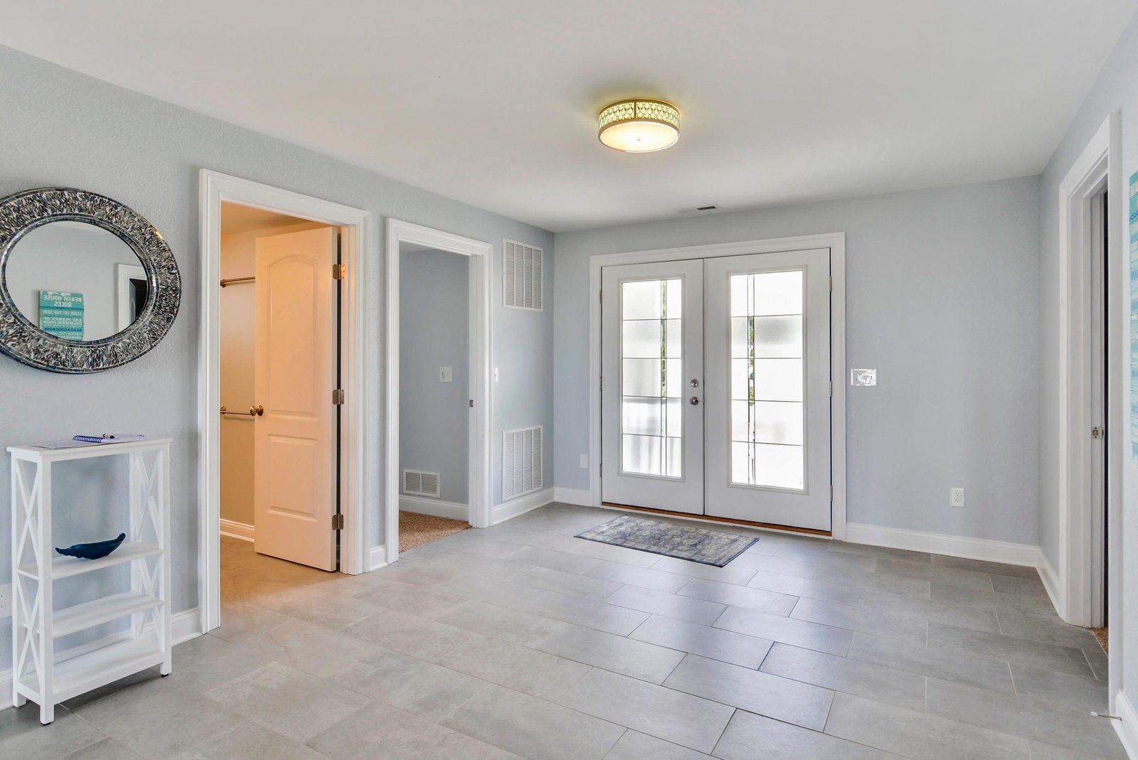 Step into your welcoming entrance where soft gray tones and abundant natural light through French doors greet you home. The spacious tiled foyer sets a calm, elegant tone for your stay.