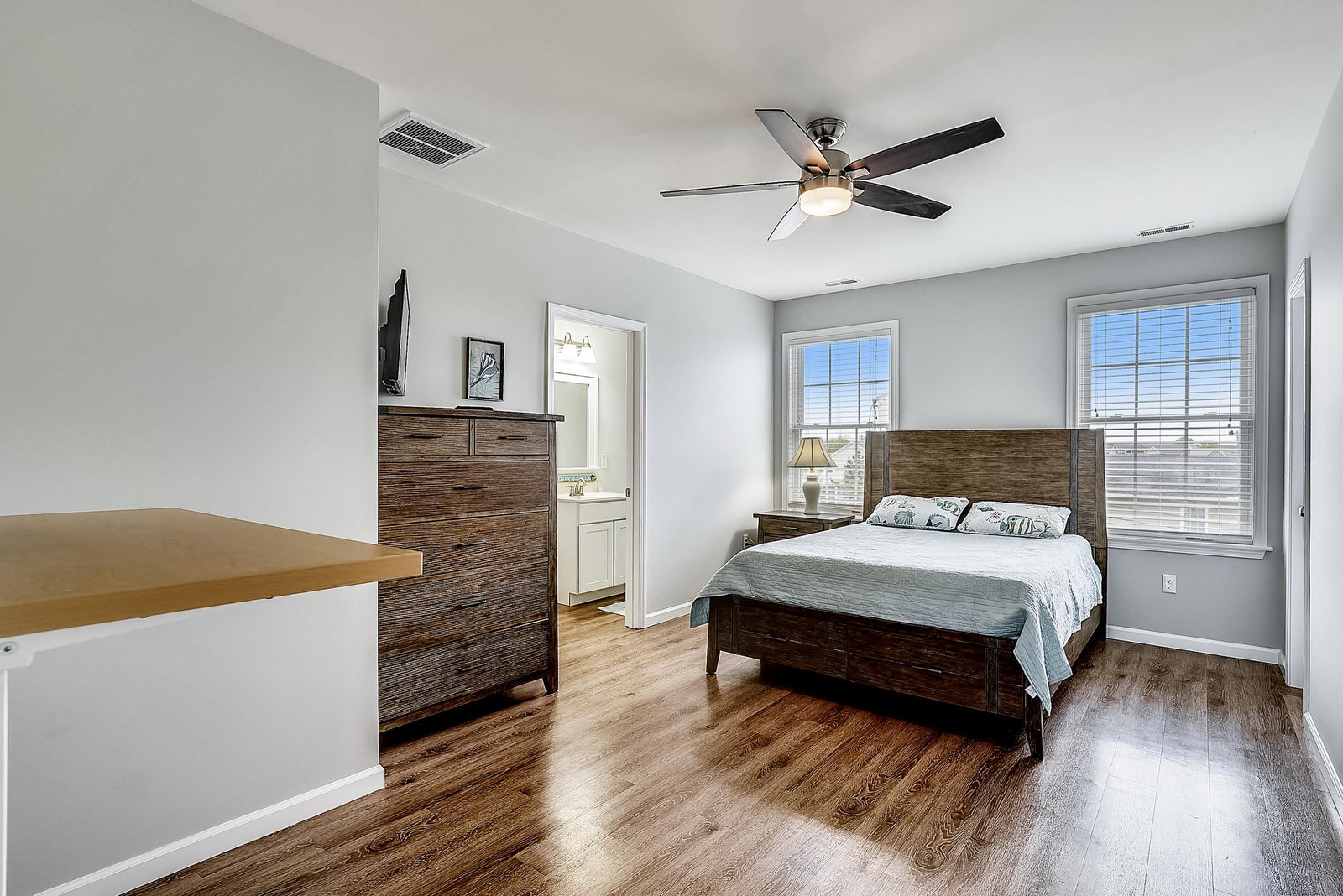 Unwind in your peaceful bedroom, where polished wood floors and soft natural light create a calming retreat. A ceiling fan keeps you comfortable all season long.
