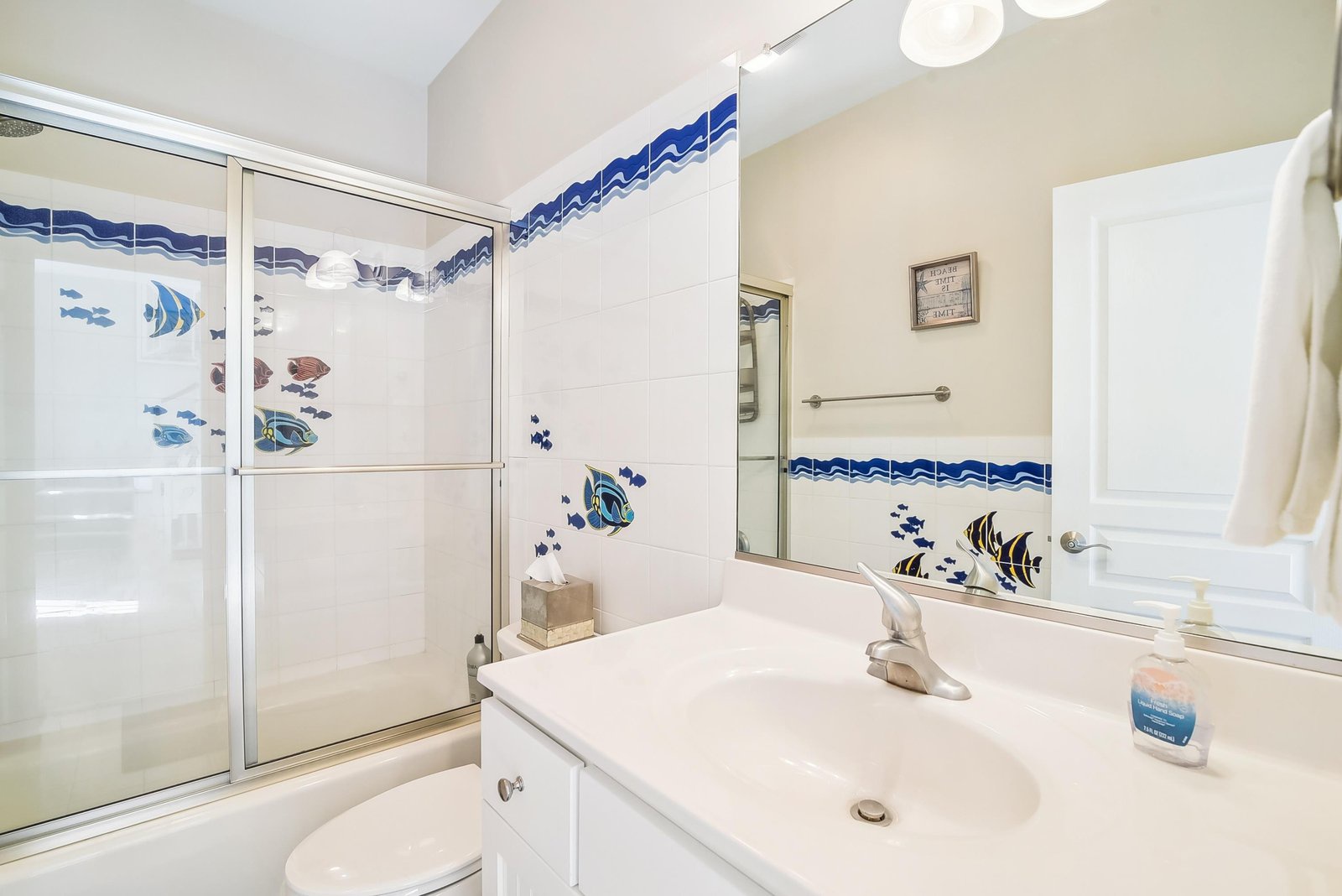Your bathroom features a spacious walk-in shower and bright, beach-inspired tiling, creating a clean and welcoming retreat after a day of exploring.