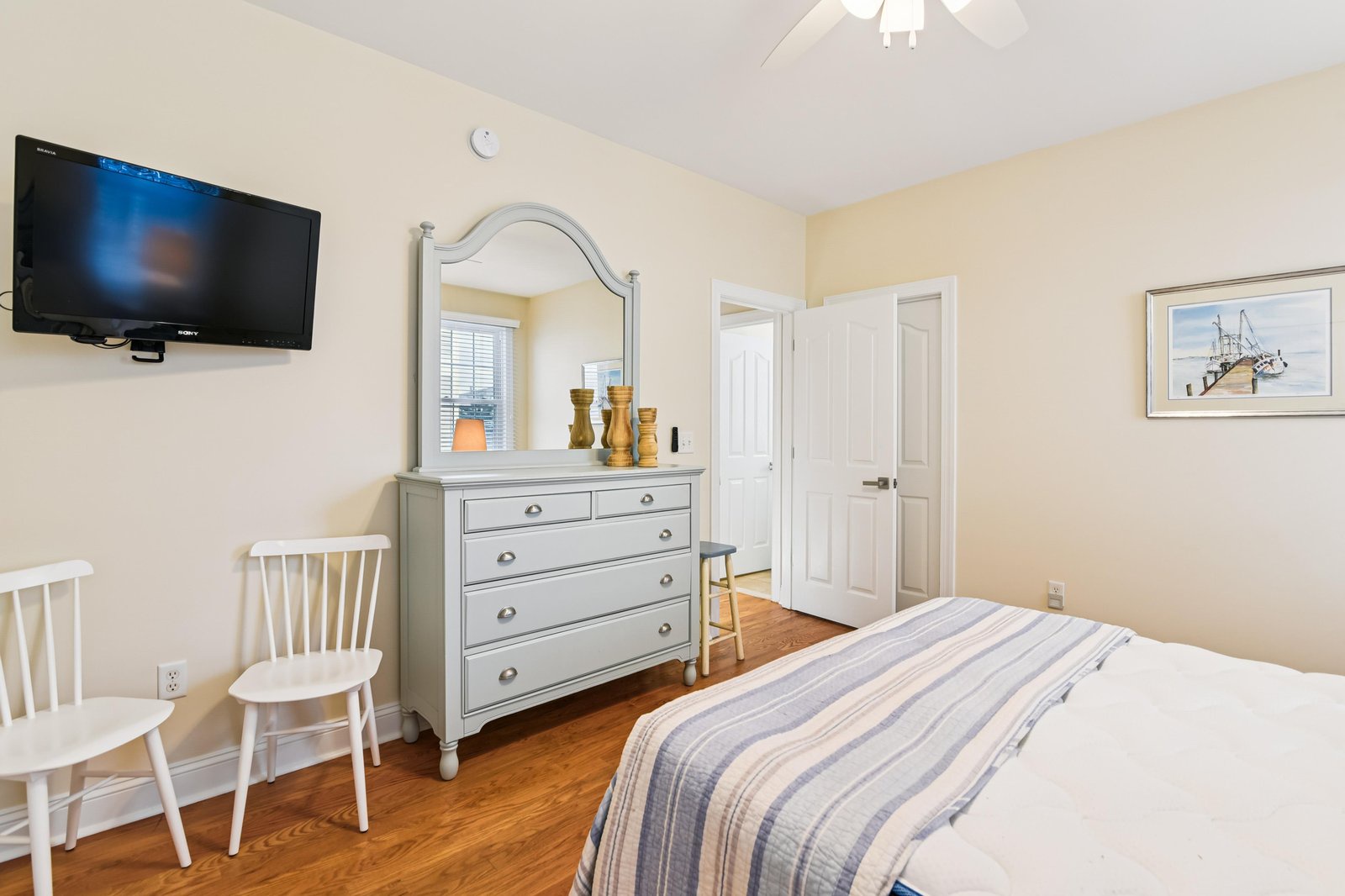 Unwind in this cozy bedroom featuring coastal charm with soft linens, warm wood floors, and thoughtful touches that make your stay feel like home.