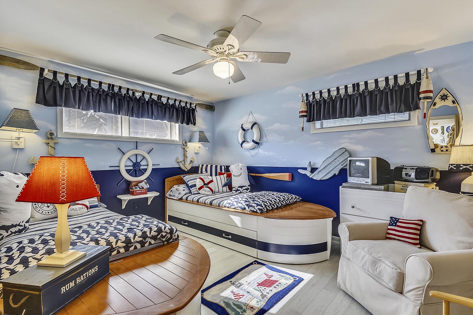 Set sail into comfort in this charming nautical-themed bedroom, where crisp blue-and-white décor and cozy twin beds invite your family's seaside dreams to life.