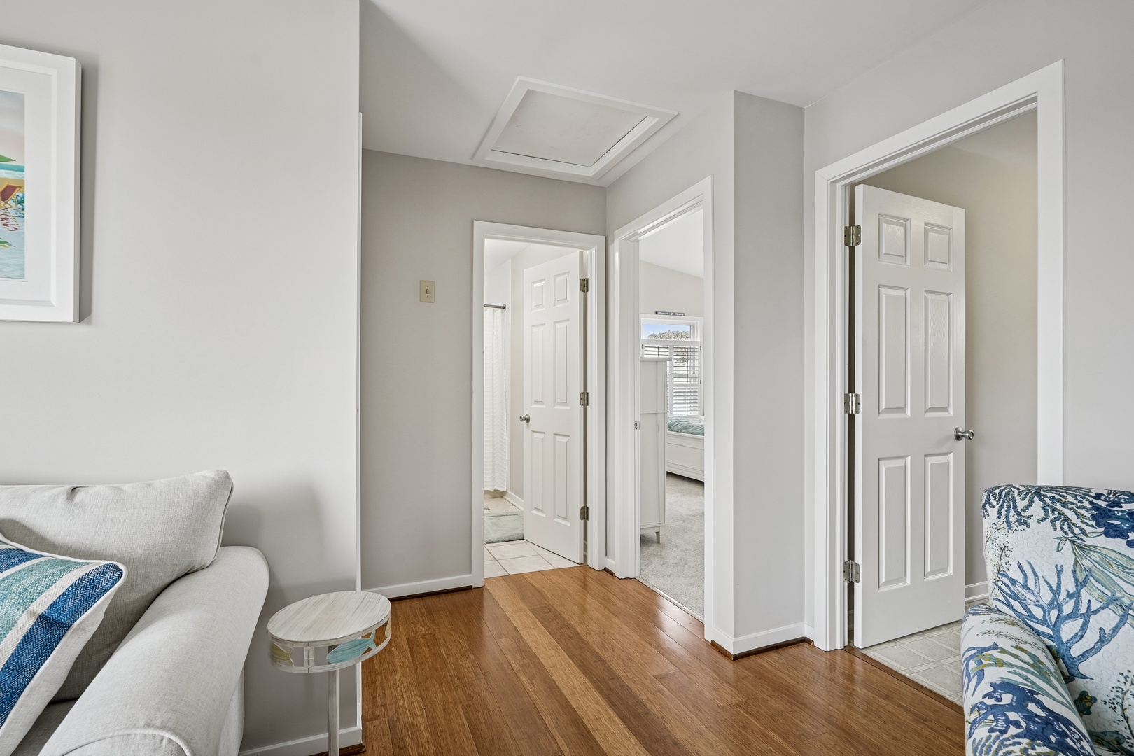 Relax in your bright living space with comfortable seating and coastal-inspired décor, where multiple doorways connect you to other rooms.