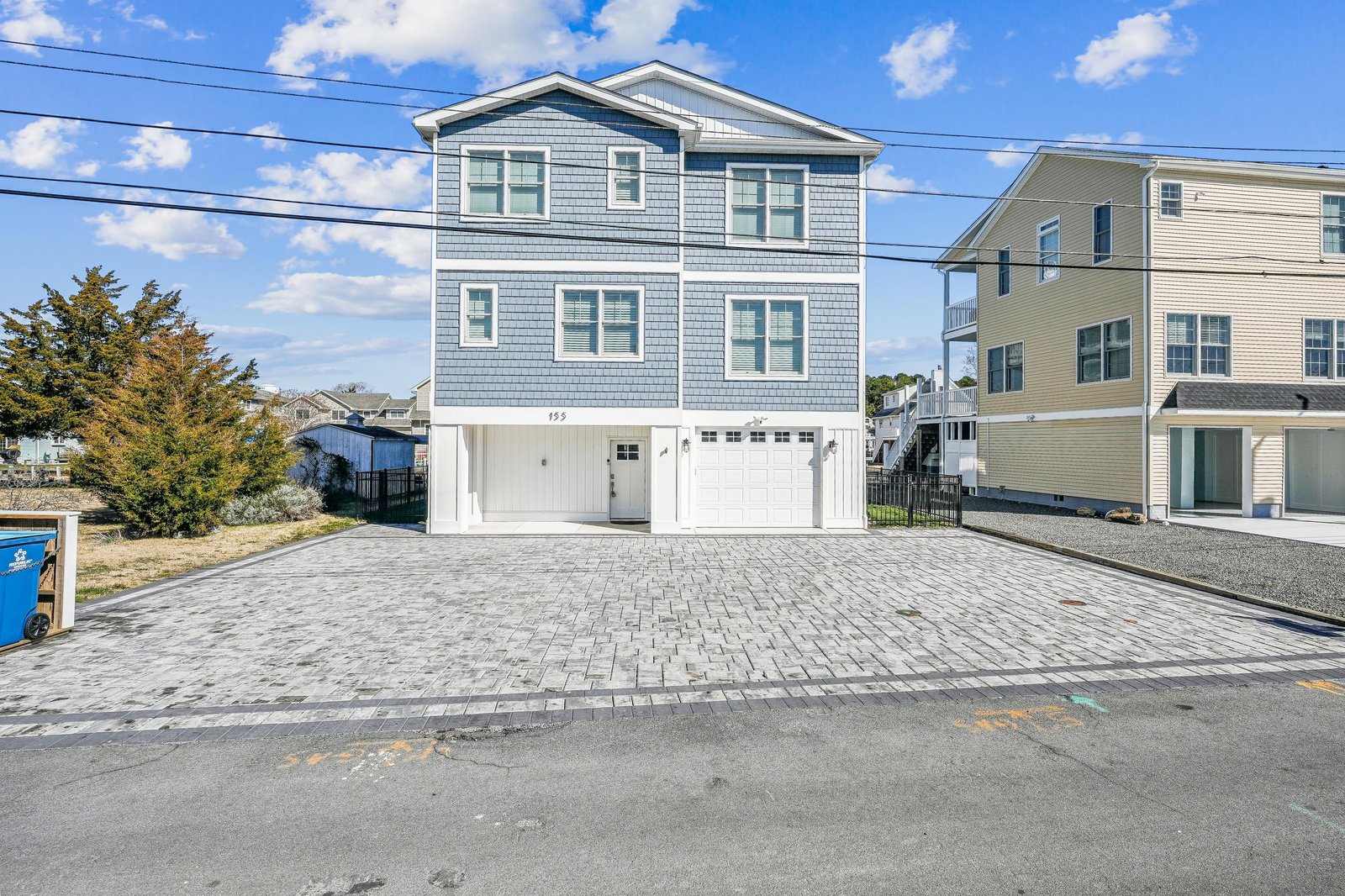 This coastal property features a spacious paver driveway and a two-car garage, offering convenient parking and easy access upon arrival.