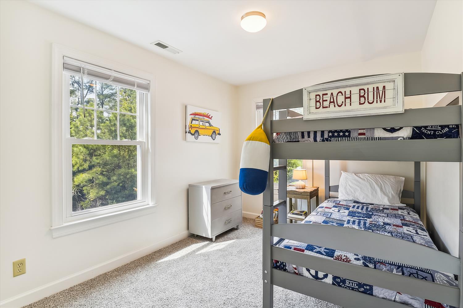 Your little ones will love this cheerful coastal-themed bedroom with its sturdy bunk beds and playful nautical touches—perfect for bedtime stories and sandy day memories.
