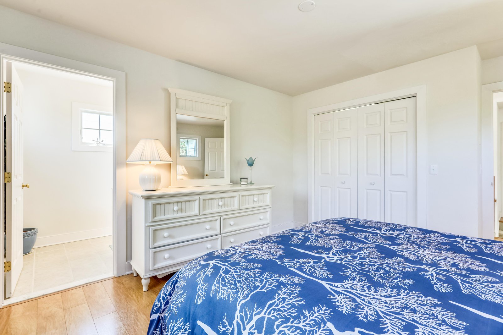 Your peaceful bedroom retreat features crisp white furnishings and coastal-inspired touches—perfect for resting after days spent exploring nearby beaches.