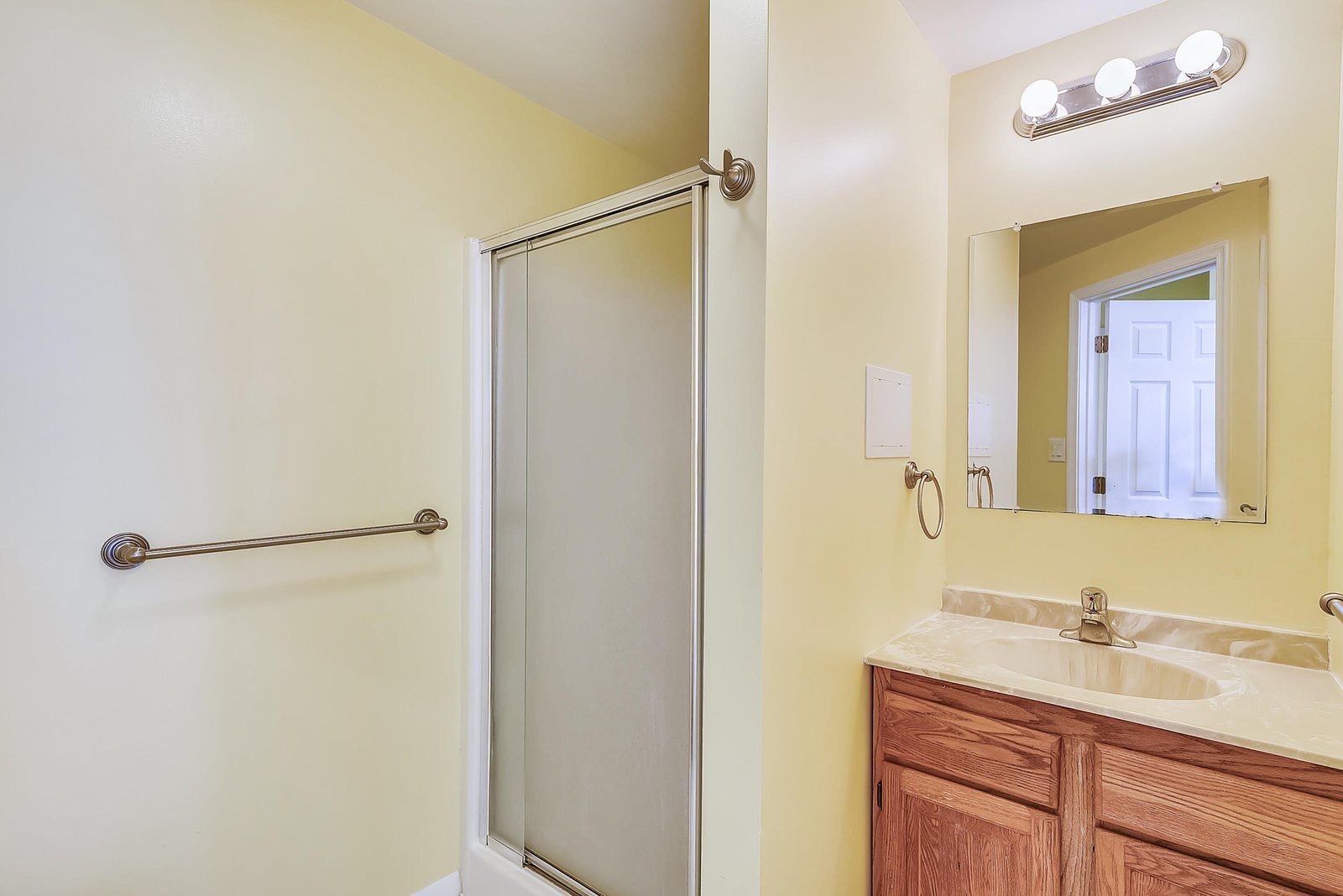 Your private bathroom features a spacious walk-in shower and ample vanity space, bathed in warm natural light for a refreshing morning routine.