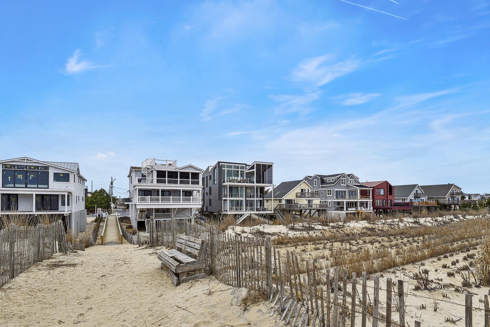 A tranquil beachfront neighborhood with charming coastal homes lining the shore, promising a peaceful seaside escape just steps from the sand.