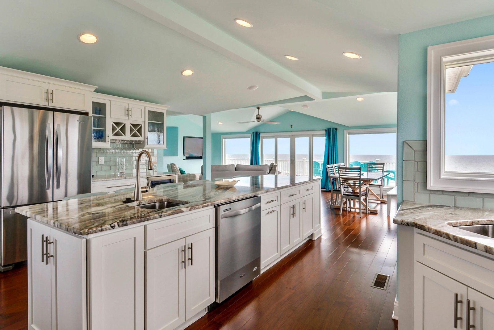 Step into your coastal dream kitchen, where gleaming granite counters and pristine white cabinetry frame stunning ocean vistas. Cook with the sea breeze at your back and dine just steps from the sand.