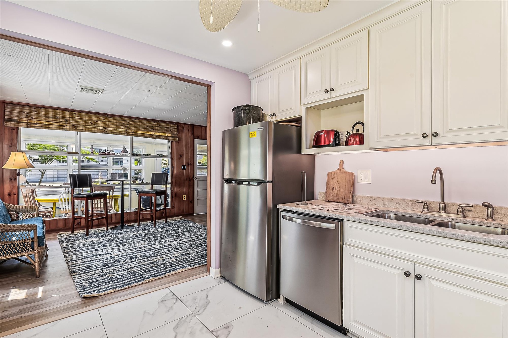 Your bright kitchen features stainless steel appliances and granite countertops, opening to a charming dining area with views of the outdoor patio beyond.