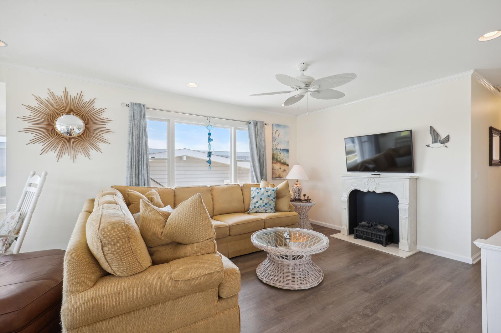 Sink into the cozy sectional and unwind in your bright, beach-inspired living space, complete with coastal charm and a flickering fireplace for cooler evenings.