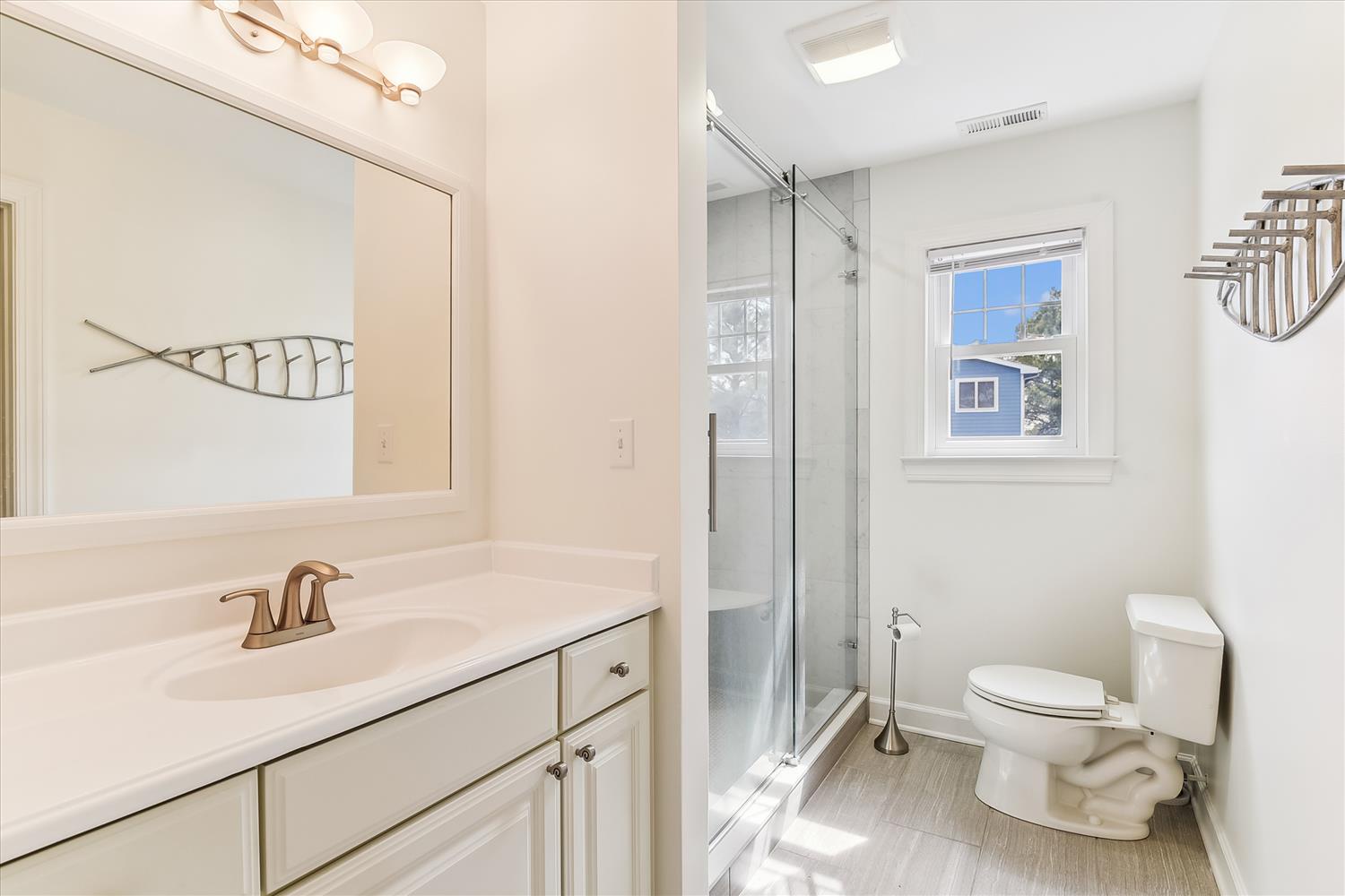 Step into your spotlessly clean bathroom with fresh coastal touches—your private space to refresh after a day of adventure.
