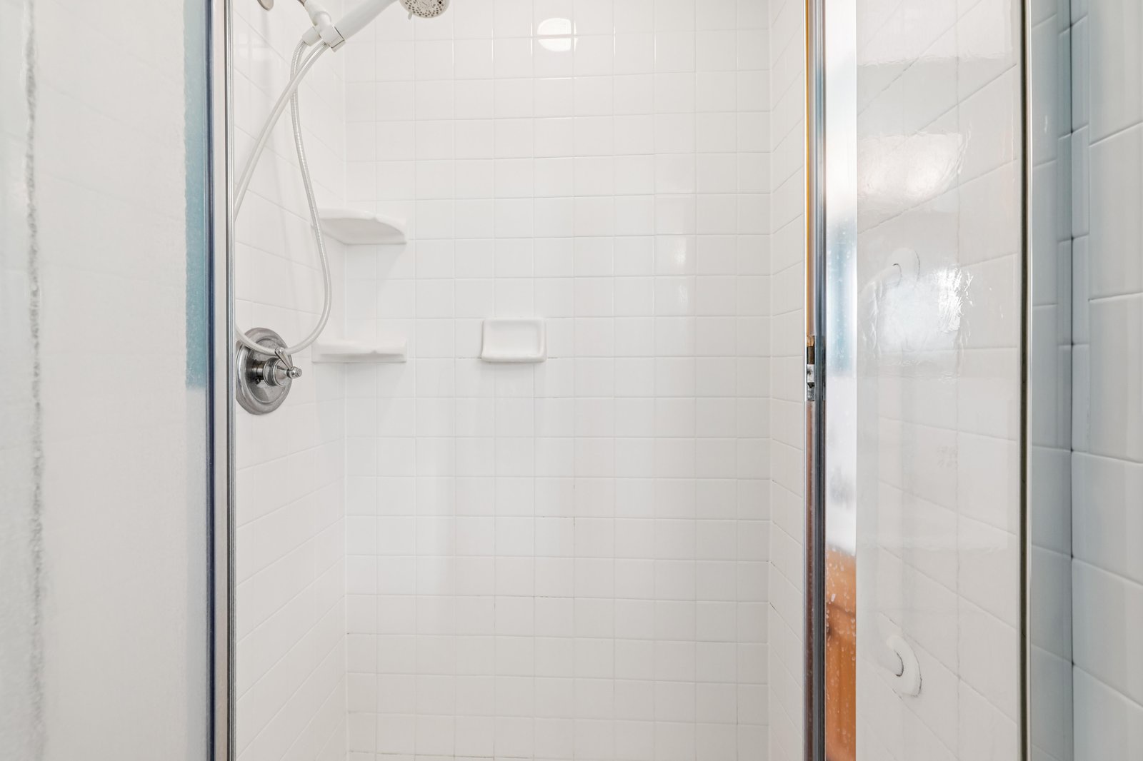 Step into your private spa-like shower, where gleaming white tiles and modern fixtures create a serene retreat after your day's adventures.